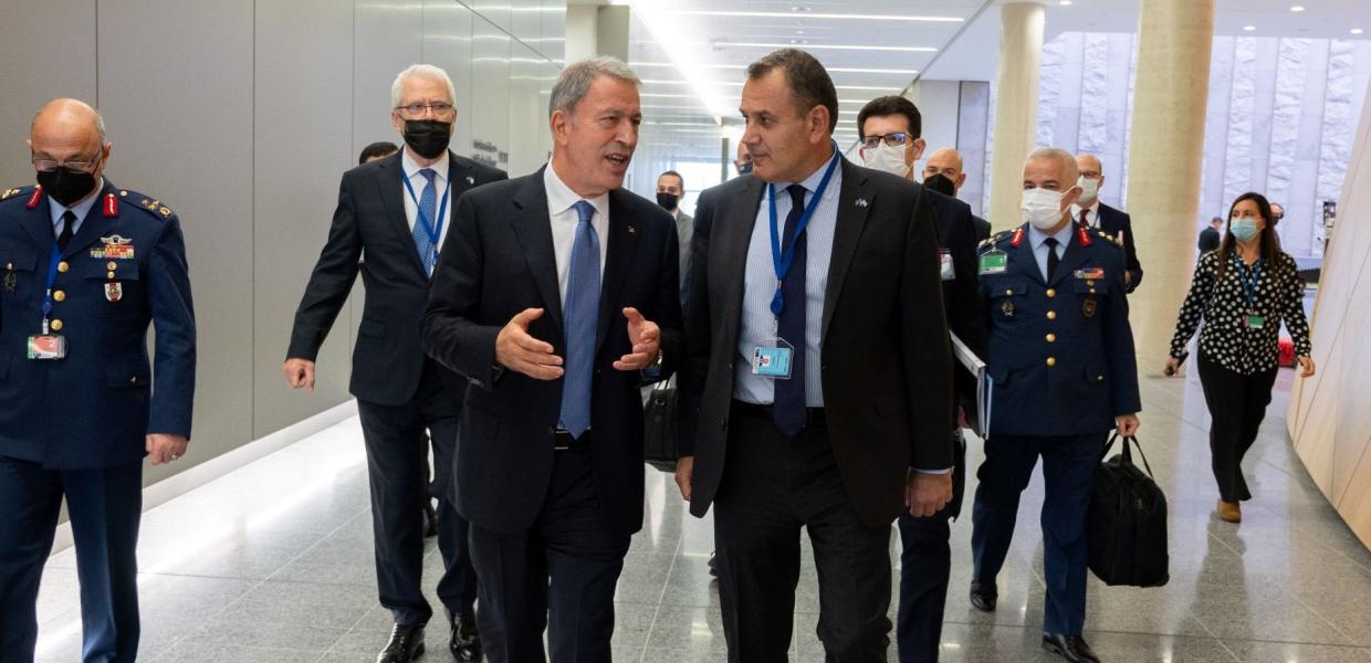 Ο Χουλουσί Ακάρ και ο Νίκος Παναγιωτόπουλος περπατούν σε διάδρομο και συνομιλούν