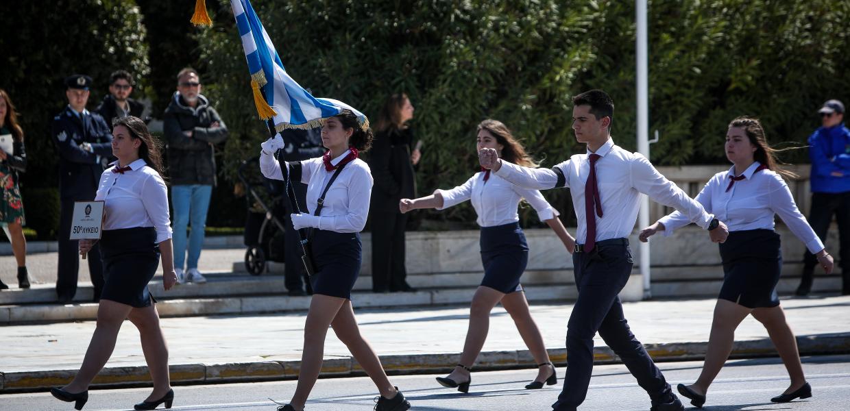 Η σημαιοφόρος και οι παραστάτες Λυκείου με μαύρα περιβραχιόνια για την τραγωδία στα Τέμπη στην παρέλαση