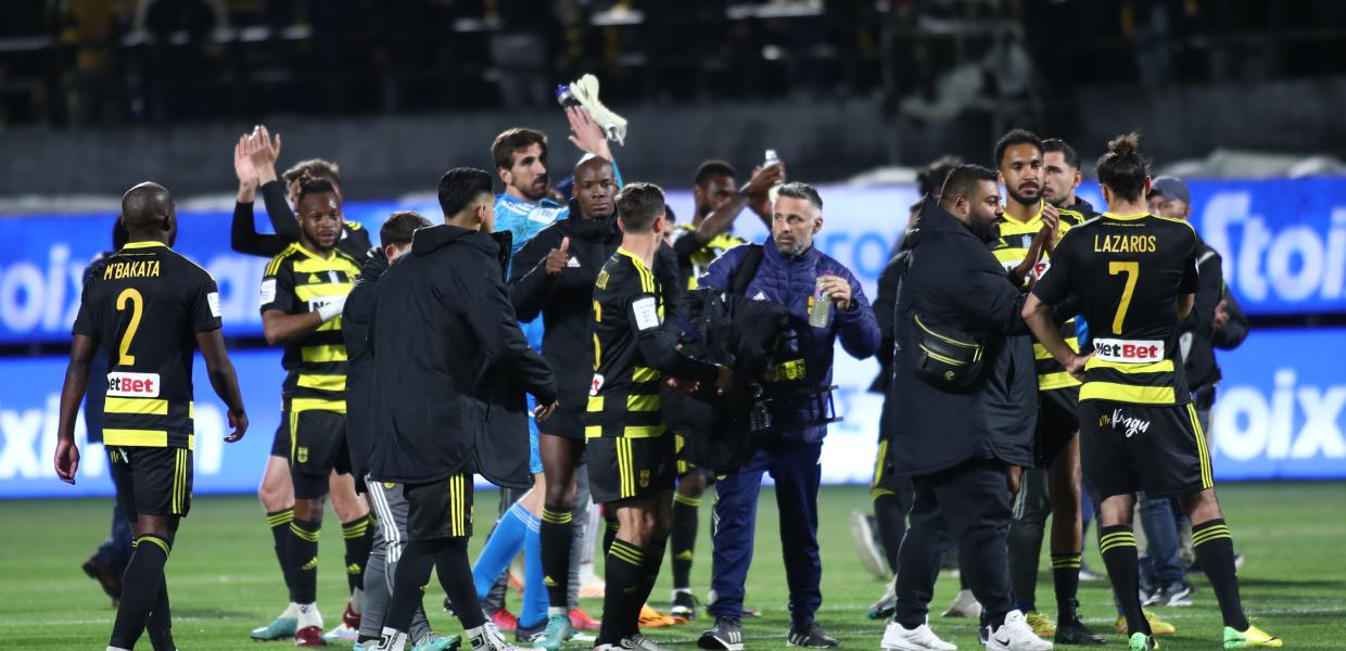 Παίκτες του Άρη αγκαλιάζονται στο γήπεδο μετά τη νίκη