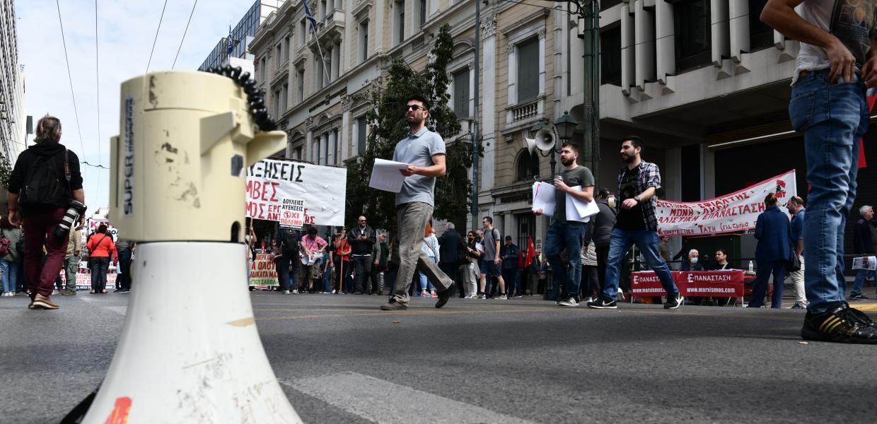 Ντουντούκα στον δρόμο και από πίσω κόσμος που συμμετέχει στη συγκέντρωση με πανό