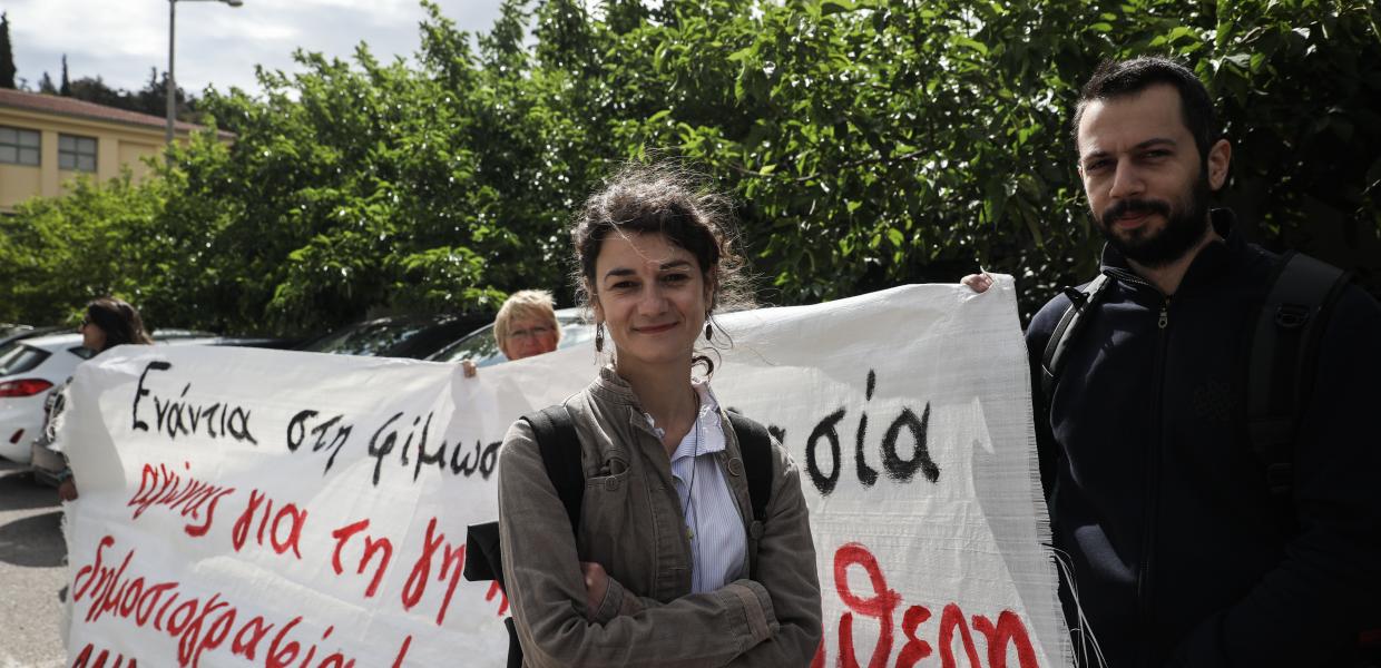 Η Σταυρούλα Πουλημένη δίπλα σε ένα άντρα που κρατά την άκρη ενός πανό