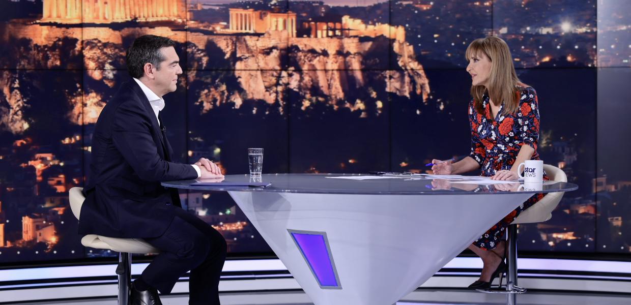 Ο Αλέξης Τσίπρας με τη Μάρα Ζαχαρέα την ώρα της τηλεοπτικής συνέντευξης κάθονται αντικριστά στο τραπέζι του στούντιο