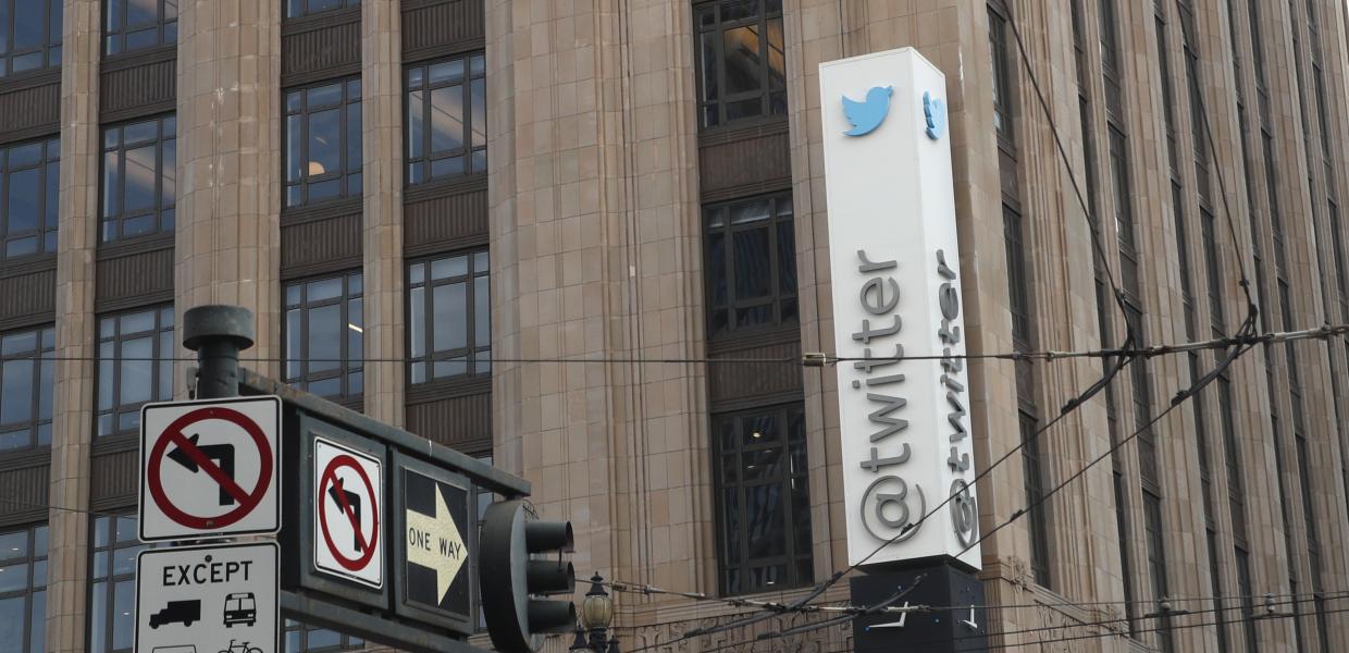 Πινακίδα του Twitter σε κτίριο της εταιρείας και μπροστά φανάρια και πινακίδες σε δρόμο