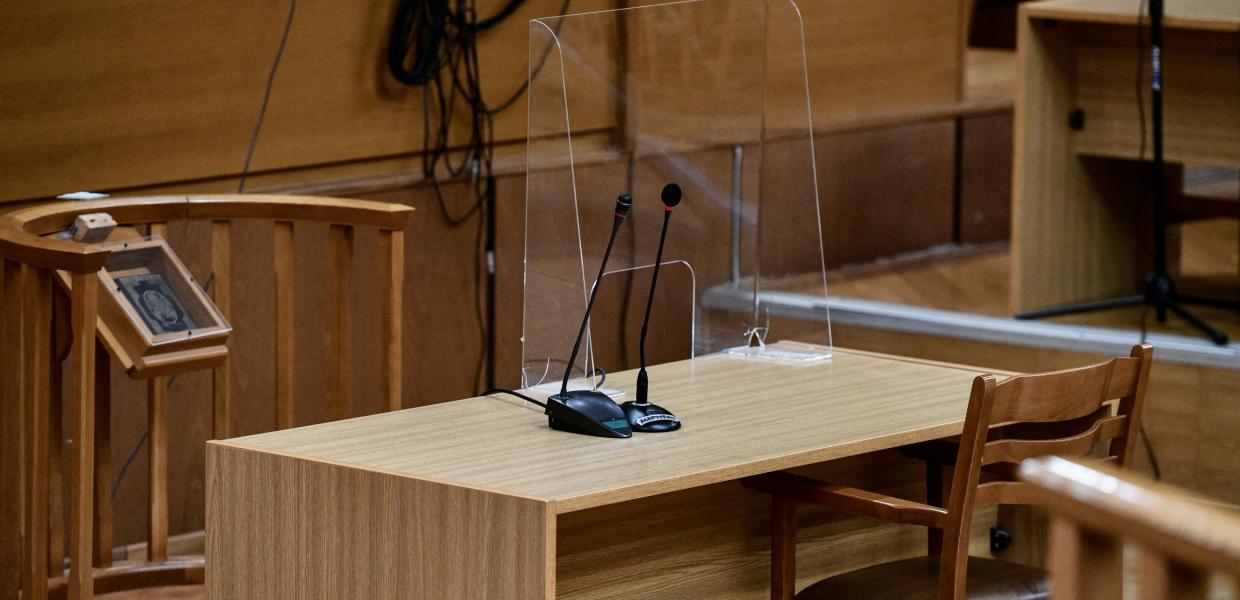 Στιγμιότυπο από δικαστική αίθουσα με το βήμα και μπροστά θρησκευτική εικόνα 