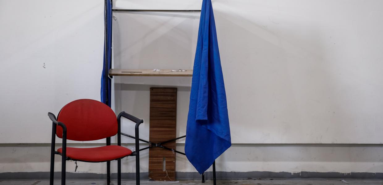 Κόκκινη καρέκλα μπροστά σε ανοιχτό παραβάν όπιου ψηφίζουν οι πολίτες 