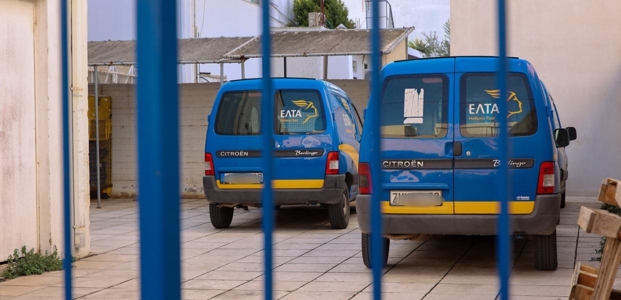 Αυτοκίνητα των ΕΛΤΑ σε πάρκινγκ πίσω από σίδερα πόρτας 