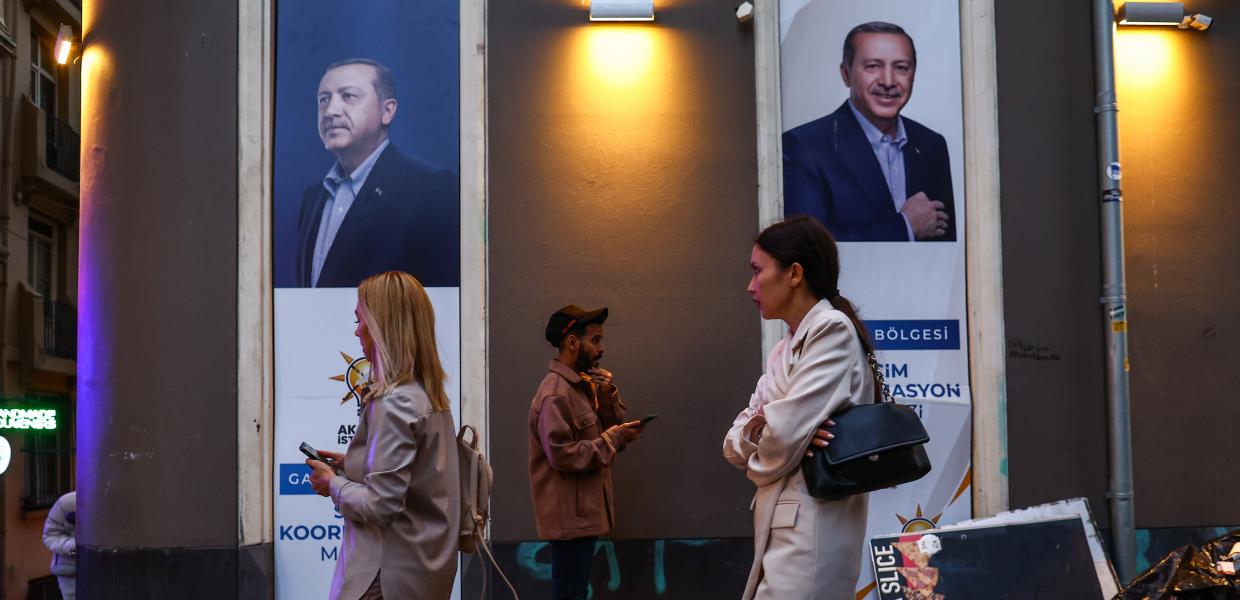 Κόσμος περνά μπροστά από προεκλογικές αφίσες του Ερντογάν