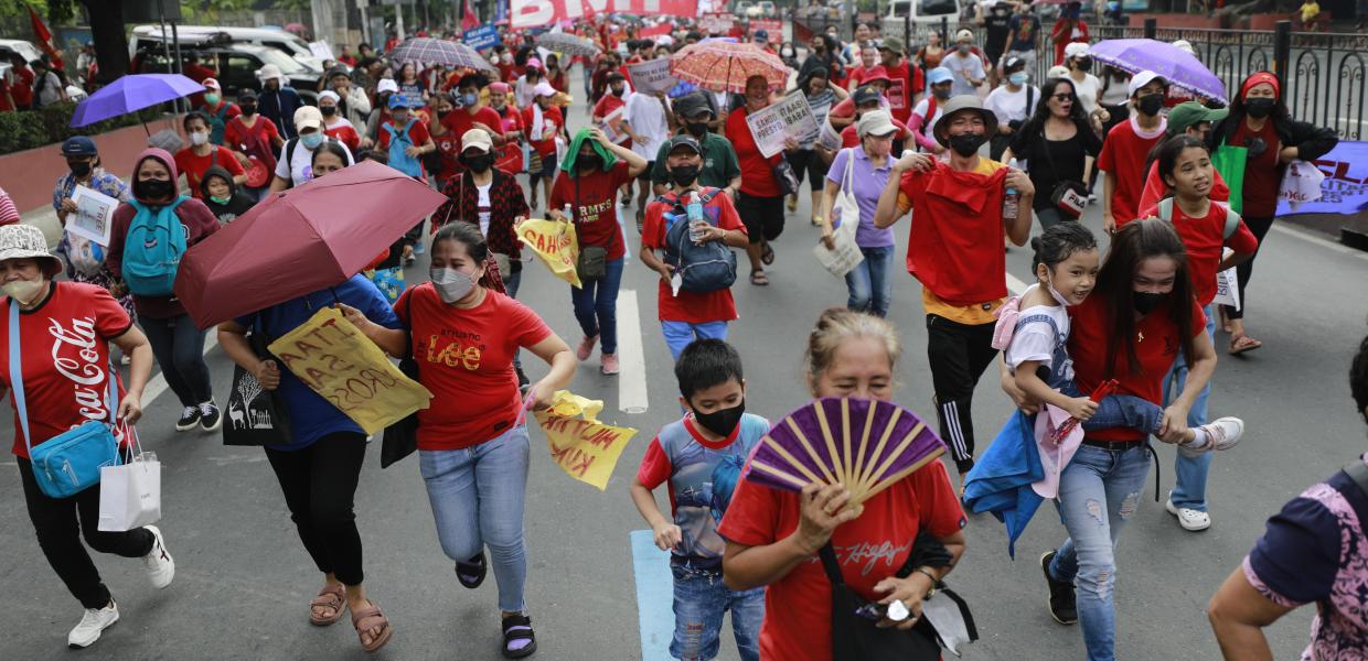 Γυναίκες με βεντάλιες και ομπρέλες στις Φιλιππίνες συμμετέχουν σε πορεία