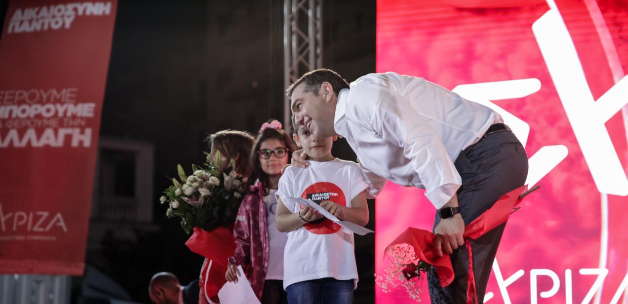 Ο Αλέξης Τσίπρας με παιδάκια που κρατούν λουλούδια στη σκηνή 