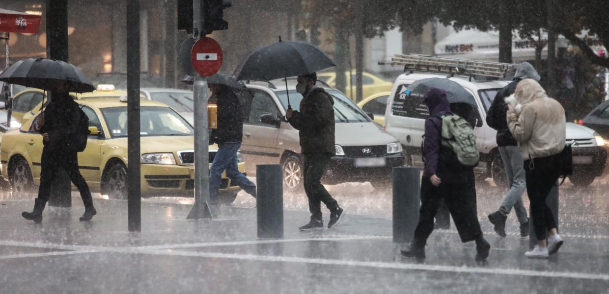Άνθρωποι με ομπρέλες στη βροχή