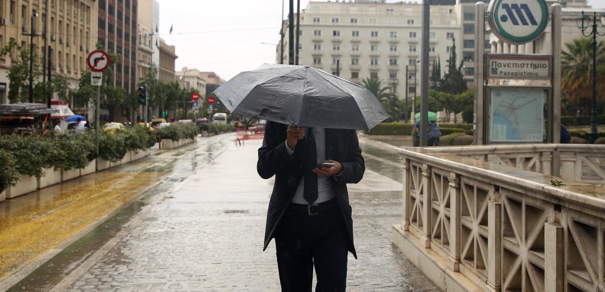 Άνθρωπος με ομπρέλα υπό βροχή