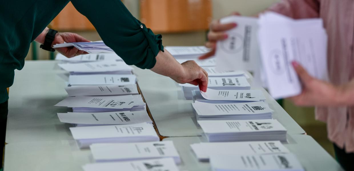 Αντρικό χέρι παίρνει τα εκλογικά ψηφοδέλτια πάνω στο θρανίο