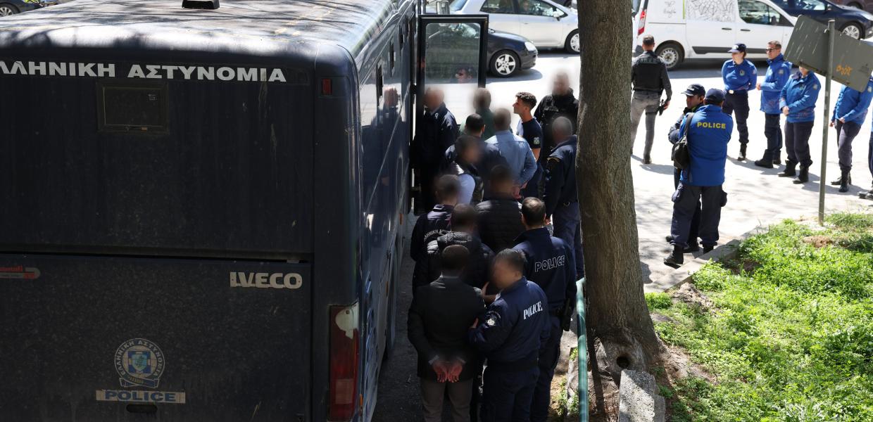 Άνθρωποι μπαίνουν σε αστυνομική κλούβα
