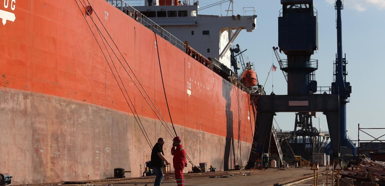 Άνθρωποι μπροστά σε πλοίο σε ναυπηγεία