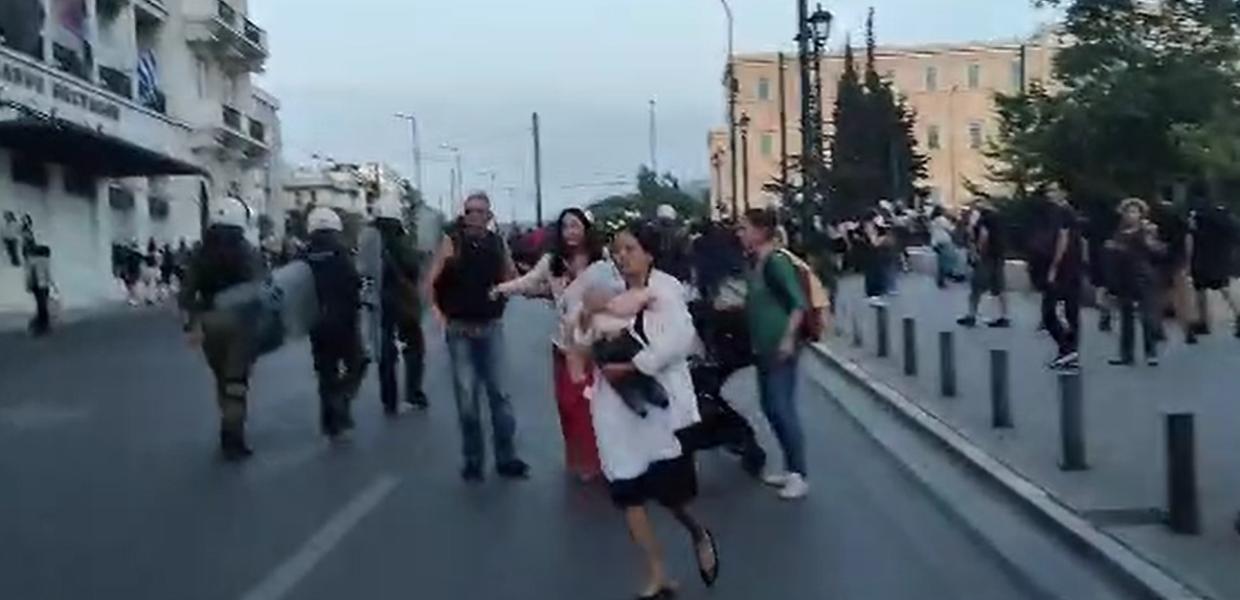 Τουρίστια με το μωρό στα χέρια φεύγει από τα ΜΑΤ