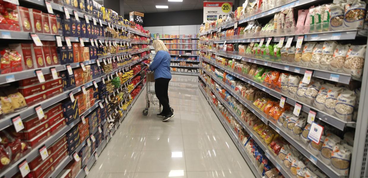 Μια κυρία με το καρότσι σε διάδρομο σούπερ μάρκετ 