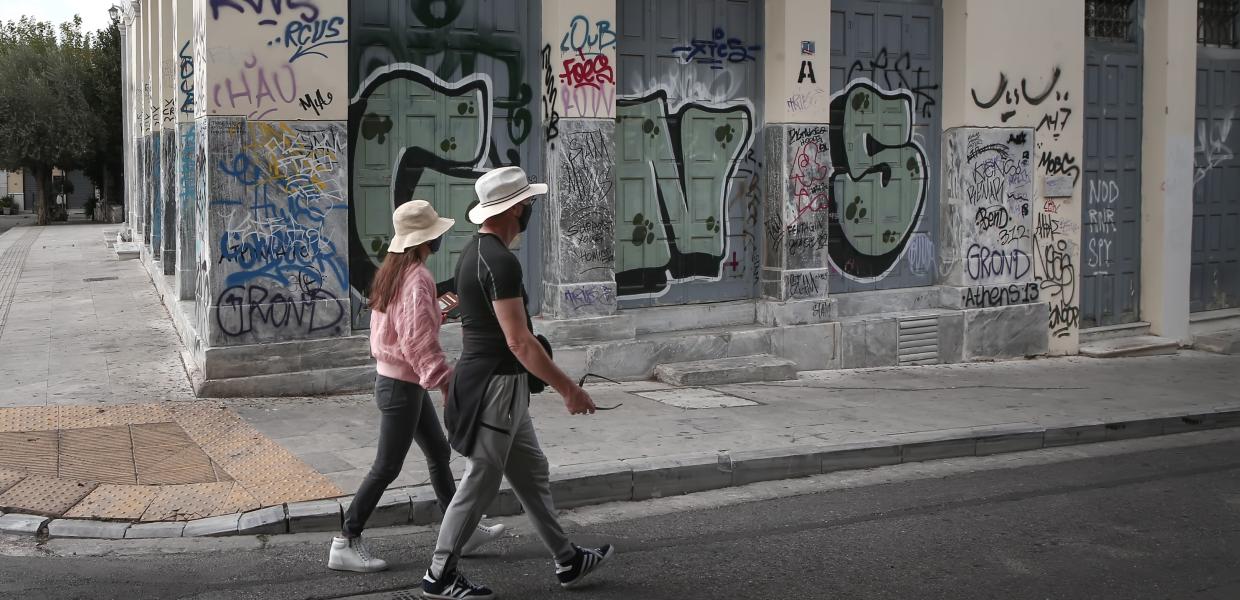 Άνθρωποι περπατούν στην Αθήνα με μάσκα