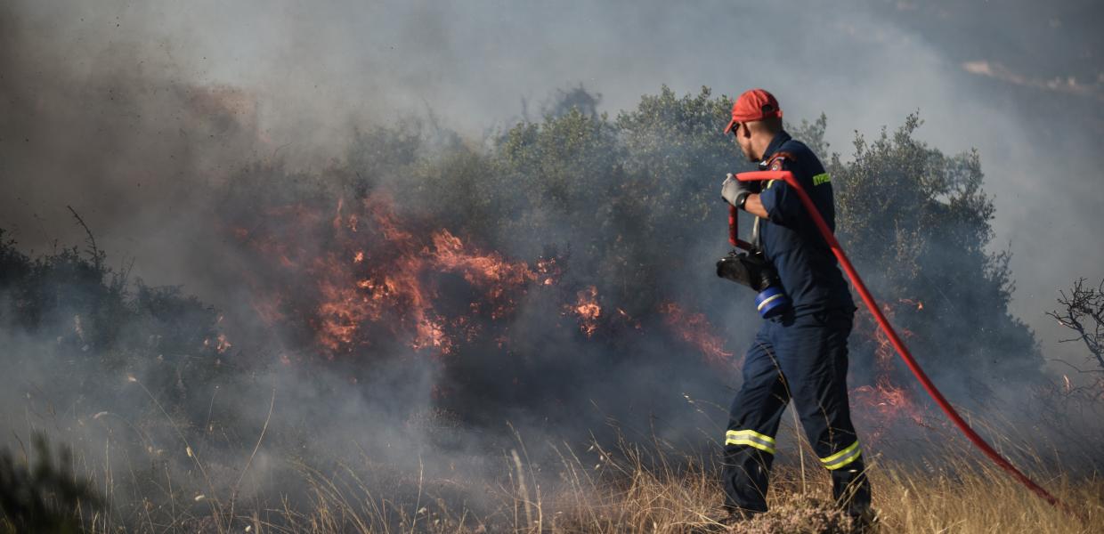 πυροσβέστης σβήνει φωτιά