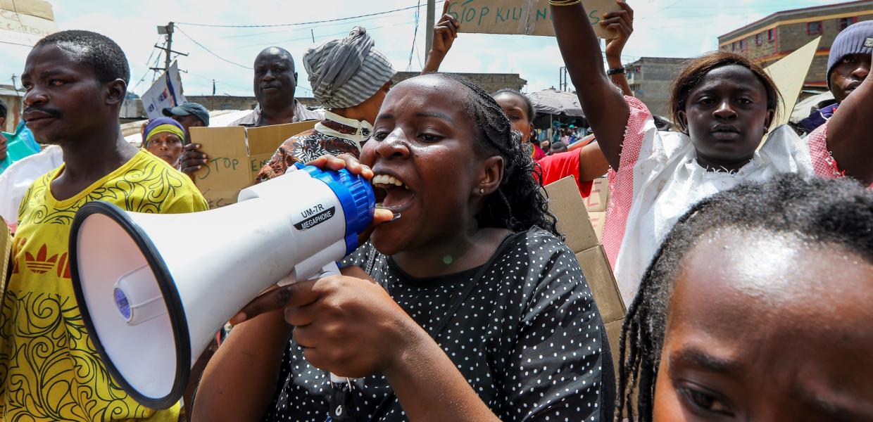 Γυναίκα με ντουντούκα και κόσμος σε διαμαρτυρία στην Κένυα
