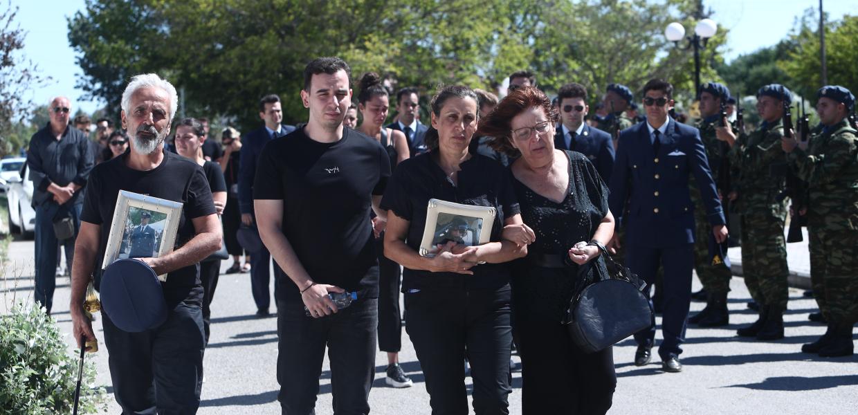 Συγγενείς στην κηδεία με φωτογραφία του νεκρού πιλότου στα χέρια τους