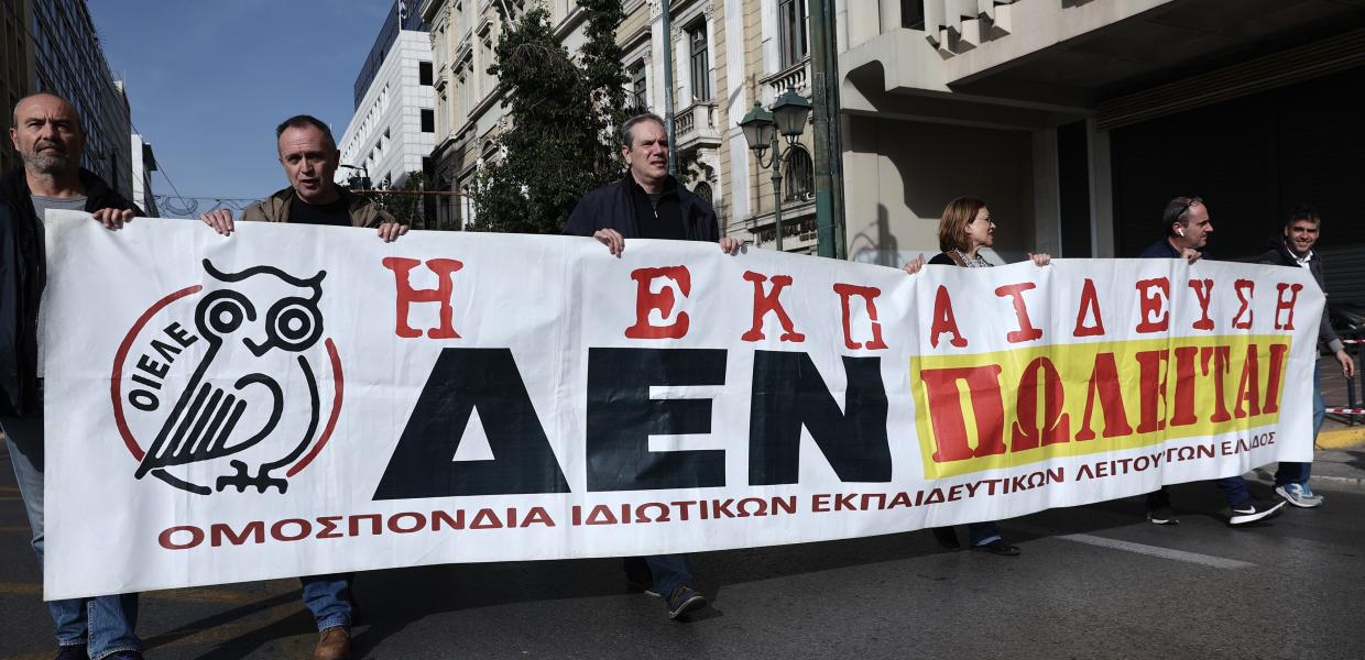 Άντρες κρατούν πανό της ΟΙΕΛΕ σε πορεία για την Παιδεία