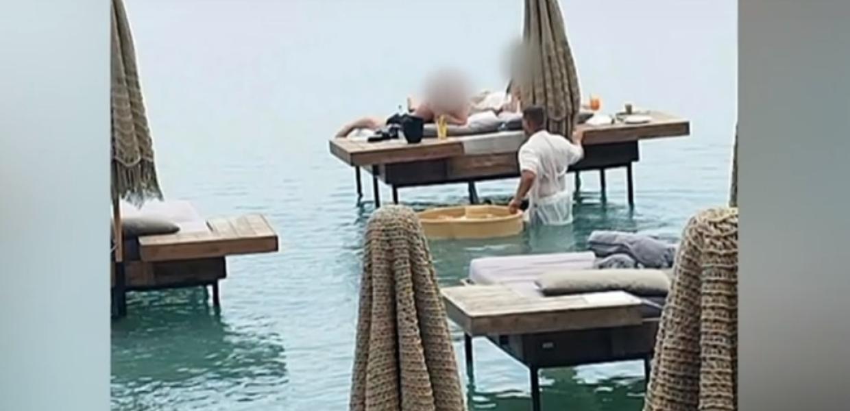 Σερβιτόρος μέσα στη θάλασσα σερβίρει πελάτες beach bar στην Ρόδο