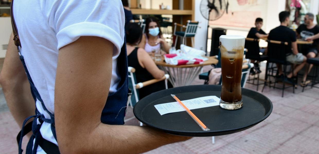 Σερβιτόρος με δίσκο στο χέρι μεταφέρει καφέ