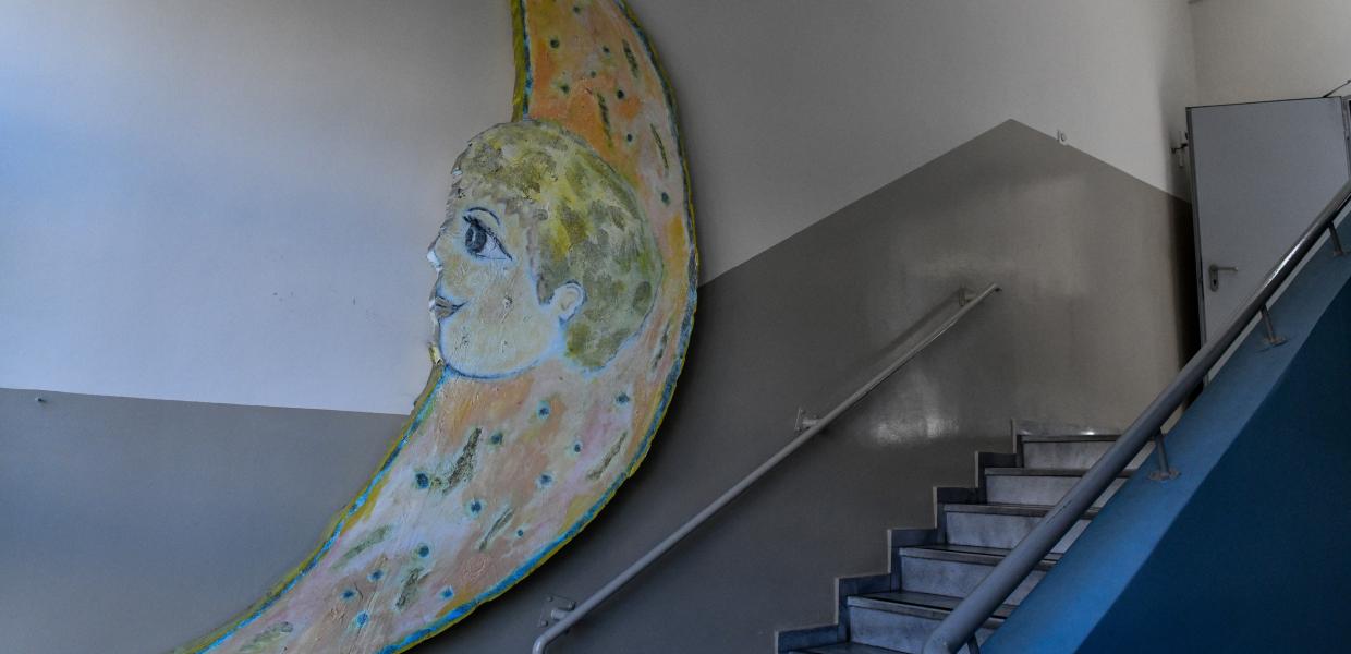 Ένα φεγγάρι σε τοίχο σχολείου δίπλα στις σκάλες