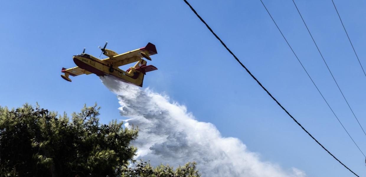 Canadair ρίχνει νερό για να σβήσει φωτιά