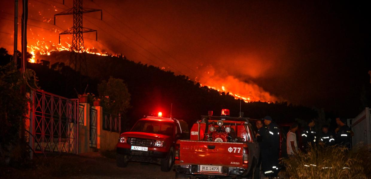 πυρκαγιά στο βουνό και μπροστά πυροσβεστικό όχημα και άνθρωποι