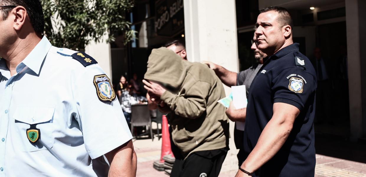 Άνθρωπος με κουκούλα δίπλα σε αστυνομικό