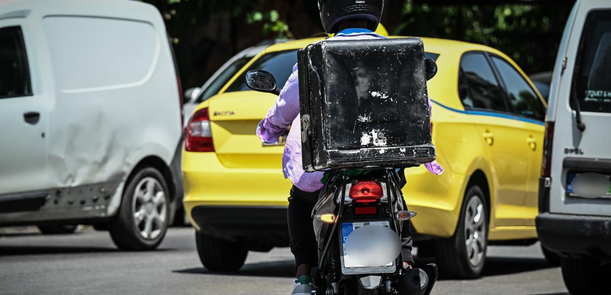 Διανομέας στον δρόμο με το μηχανάκι του