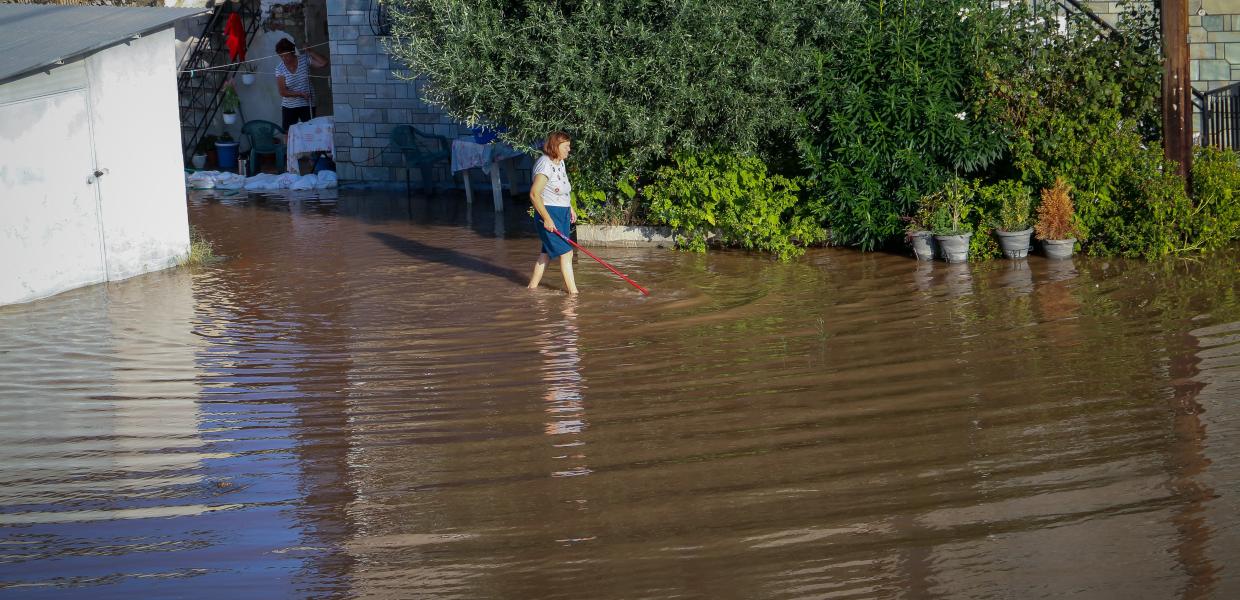 Γυναίκα σε πλημμυρισμένο από την κακοκαιρία δρόμο
