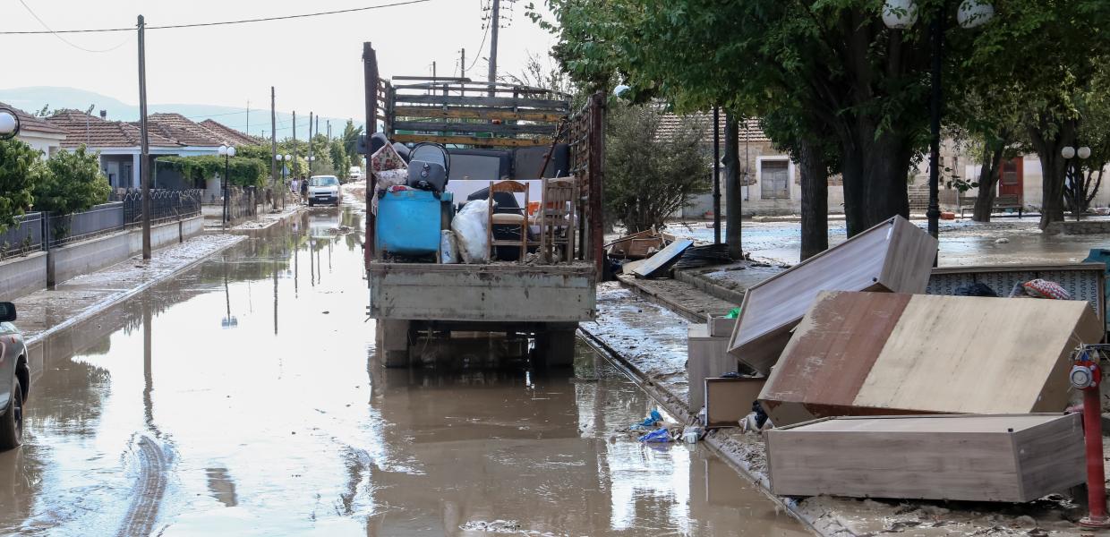 φορτηγό με πράγματα και κατεστραμμένα έπιπλα σε πλημμυρισμένο δρόμο από την κακοκαιρία