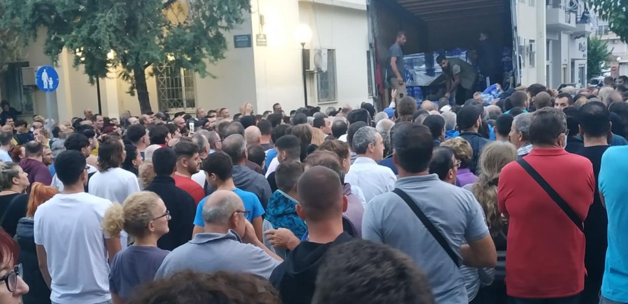 Κόσμος στην ουρά για να πάρει νερό που μοιράζουν εθελοντές από φορτηγό