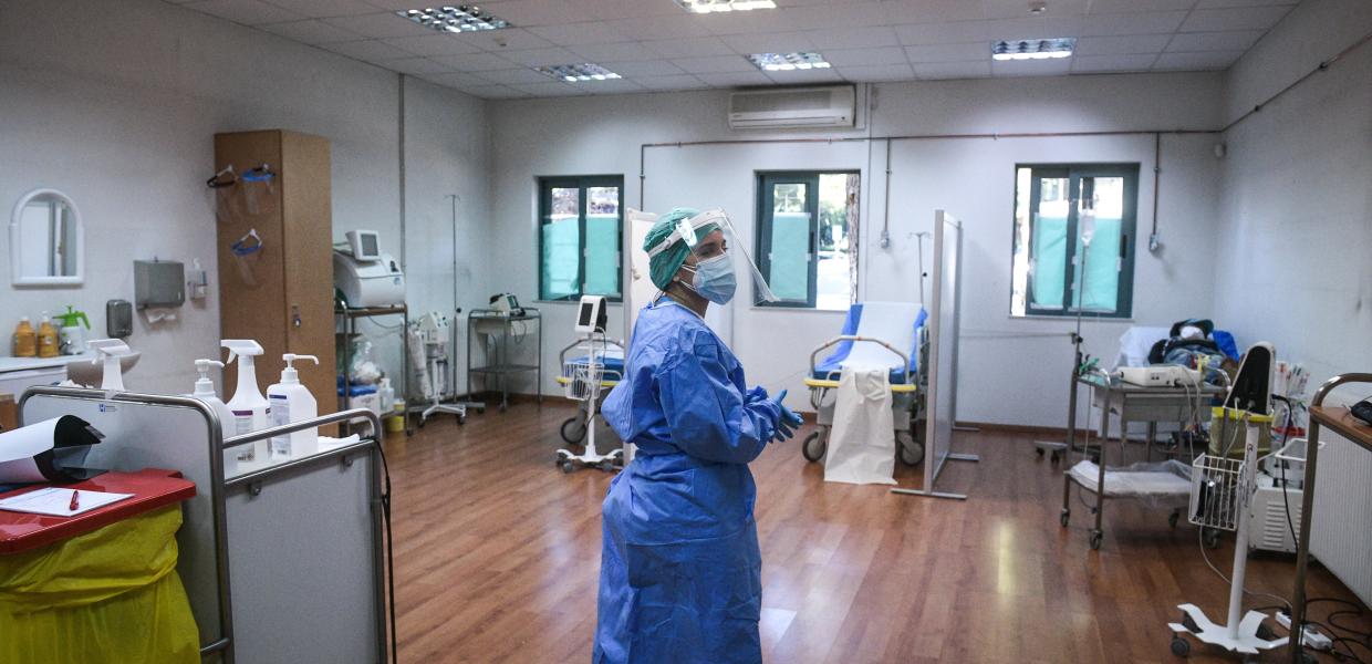 Γιατρός με ειδική στολή για covid-19 σε αίθουσα εμβολιαμσού