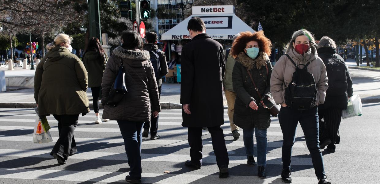 Άνθρωποι με μάσκα περπατούν στο δρόμο