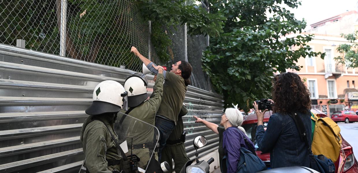 Άνθρωπος στην πλατεία Εξαρχείων με ντουντούκα απέναντι στα ΜΑΤ
