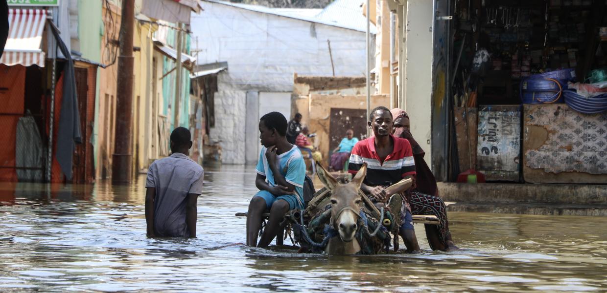 Παιδιά και κάτοικοι σε αυτοσχέδιο καρότσι σε πλημμυρισμένο δρόμο στη Σομαλία 