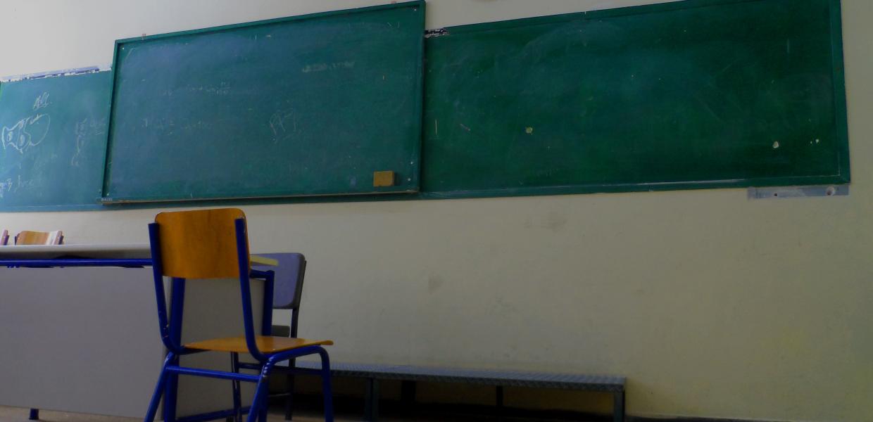 Πίνακας σε σχολική αίθουσα και μια καρέκλα μπροστά δίπλα στην έδρα