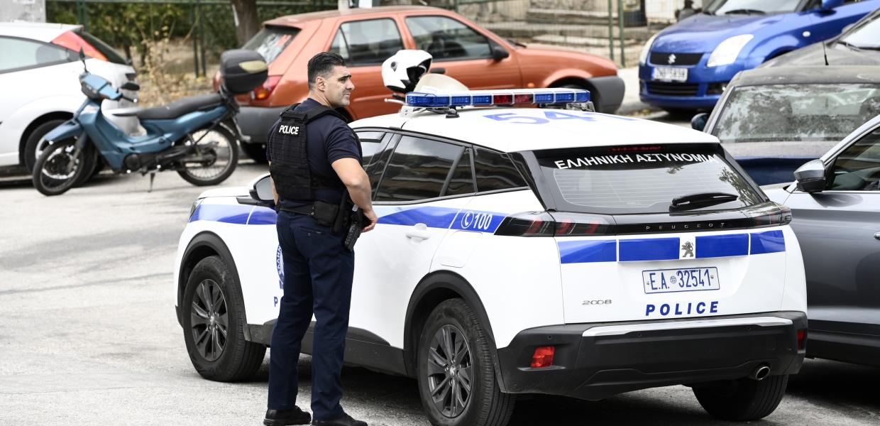 Αστυνομικός δίπλα σε περιπολικό