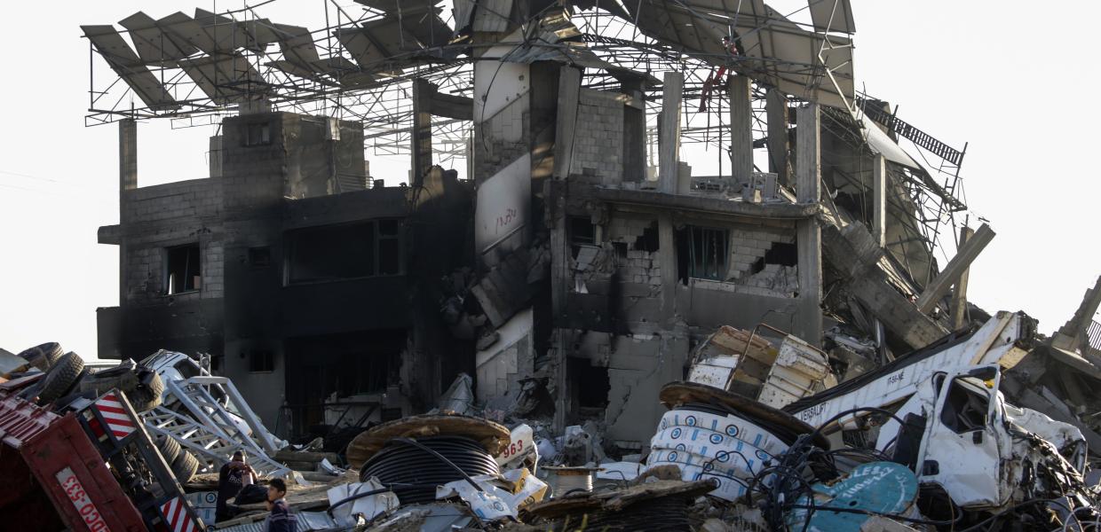 Βομβαρδισμένο κτίριο στη Γάζα και άνθρωποι