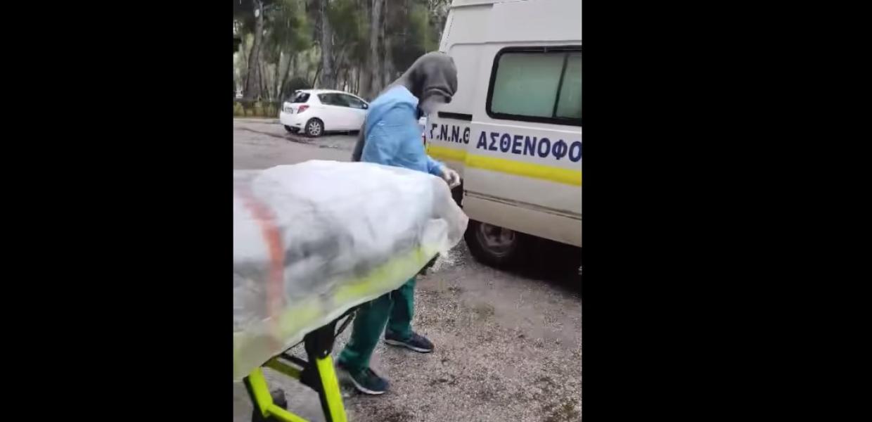 μεταφορά ασθενή που τον έχουν καλύψει με νάυλον στο ασθενοφόρο 