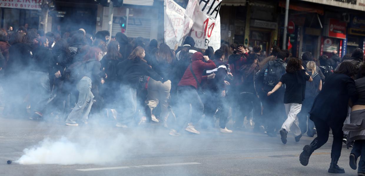 Διαδηλωτές τρέχουν και καπνός ανάμεσά τους από δακρυγόνα της αστυνομίας