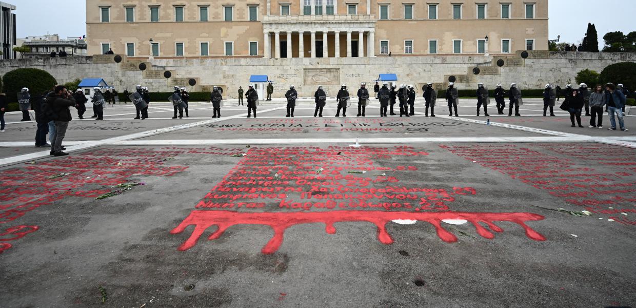 Τα ονόματα των νεκρών των Τεμπών γραμμένα με κόκκινη μπογιά μπροστά από την Βουλή