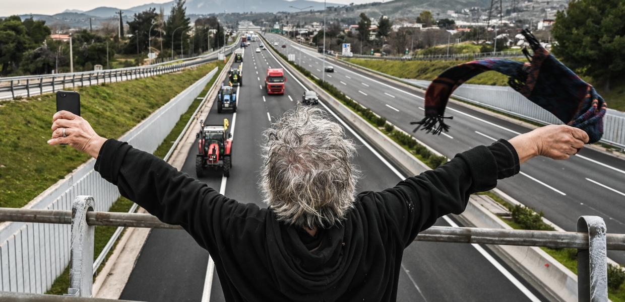 Άνθρωπος χαιρετά τρακτέρ στην εθνική οδό