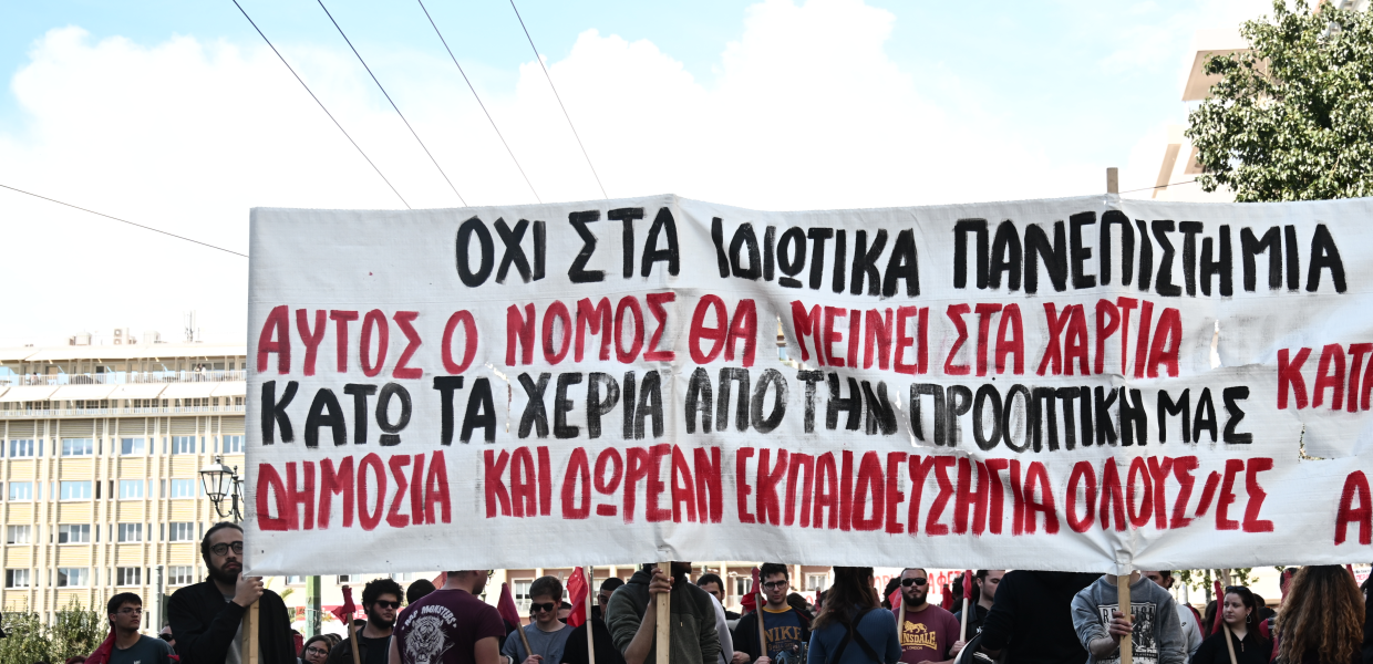Κόσμος κρατά πανό κατά των ιδιωτικών πανεπιστημίων σε πορεία στο κέντρο της Αθήνας