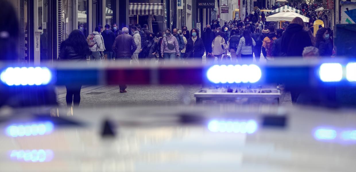 Σειρήνα περιπολικού και πίσω κόσμος που περπατά στην οδό ερμού