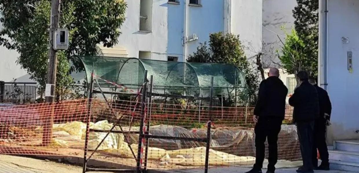 Δύο άντρες στέκονται μπροστά στην οικοδομή, από όπου έπεσε ο 59χρονος οικοδόμος στα Τρίκαλα