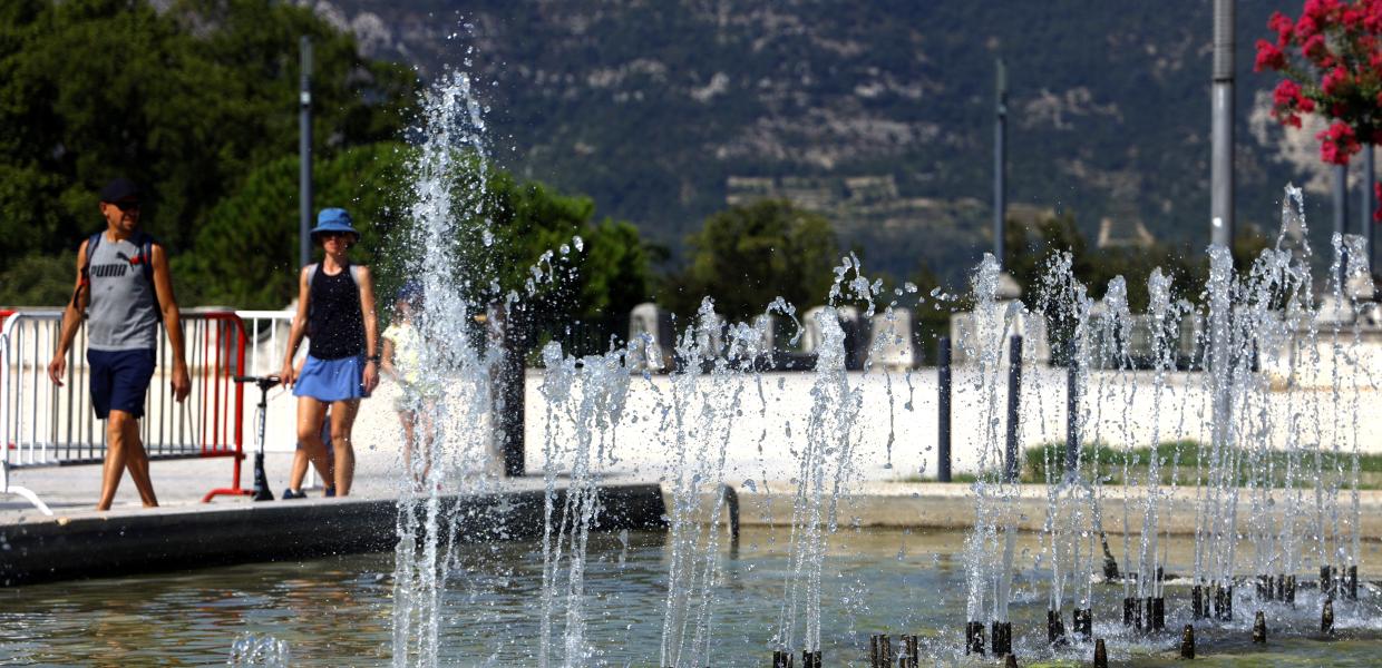 Ζευγάρι στη Γαλλία περπατά χέρι, χέρι δίπλα από συντριβάνι